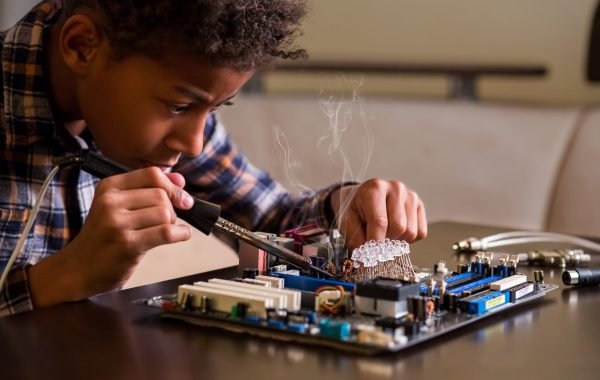 Afro boy fixing motherboard. Black kid repairs motherboard. Few touches here and there. Everything by the book.